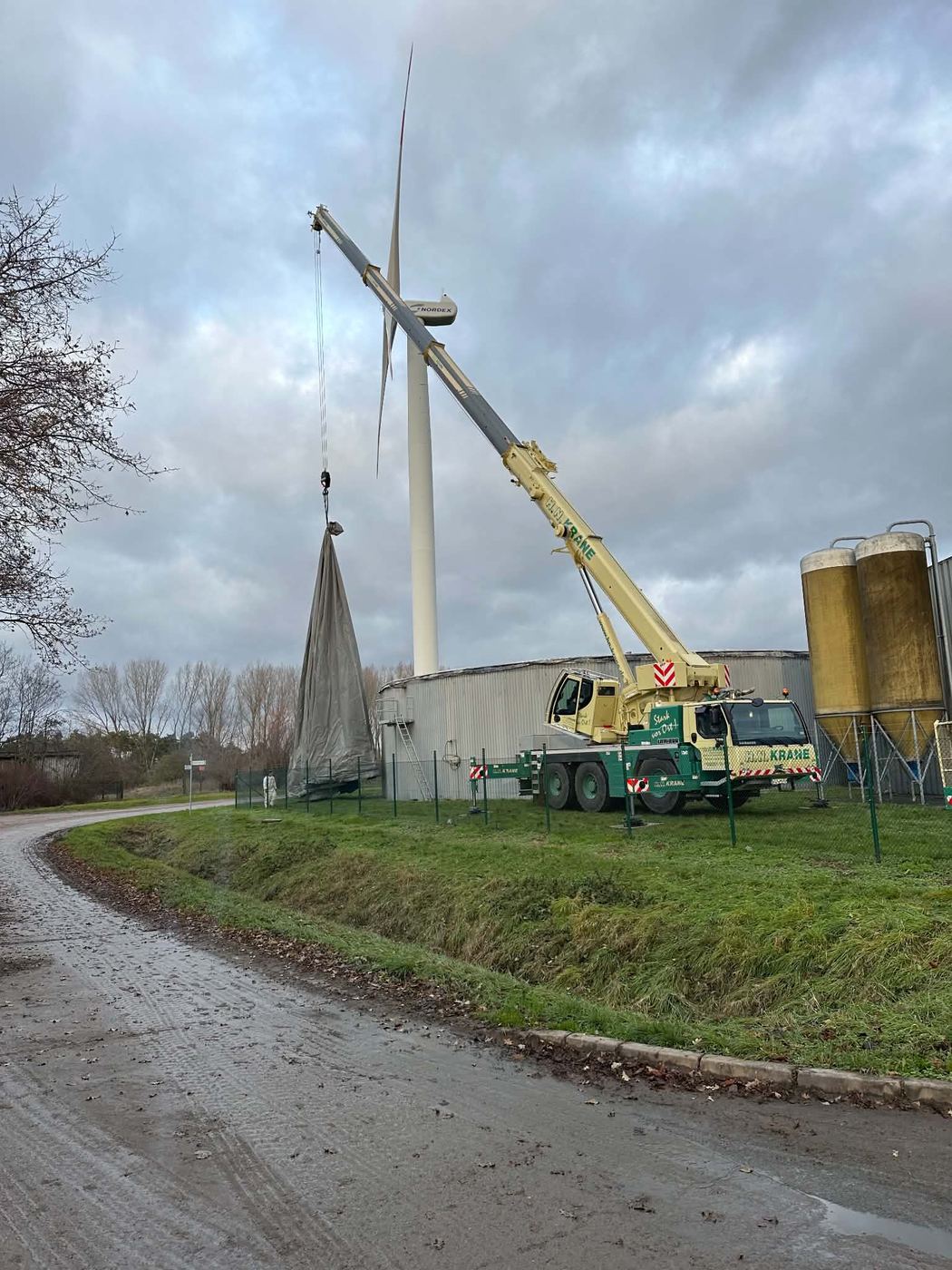 Autokran hebt die alte Dachmembran von einem Fermenter